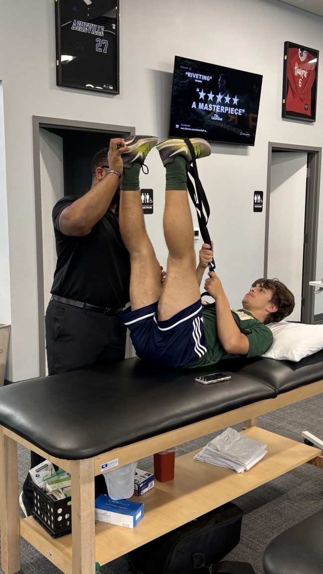 physical therapist guiding patient through therapeutic exercise in a clinic setting